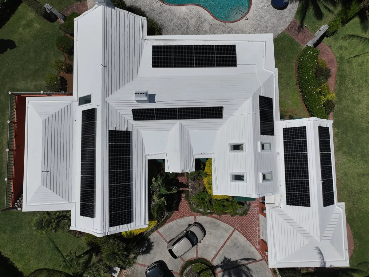 A private residence in Bermuda with Maxeon solar panels on a white roof, seen from the air